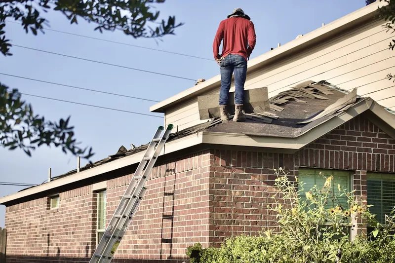 Professional roofer working on a residential roof in Millwood